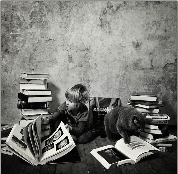 Девочка с кошкой читают книжки