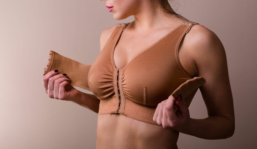 Девушка застегивает бюстгалтер 