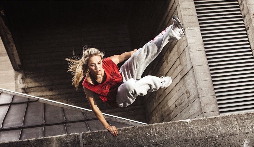 Девушка занимается паркуром 