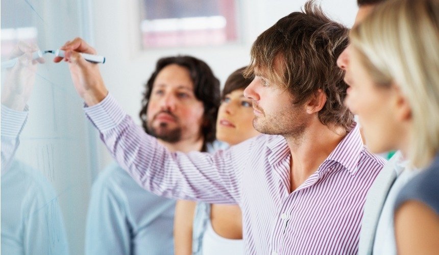 Мужчина что-то пишет на доске 