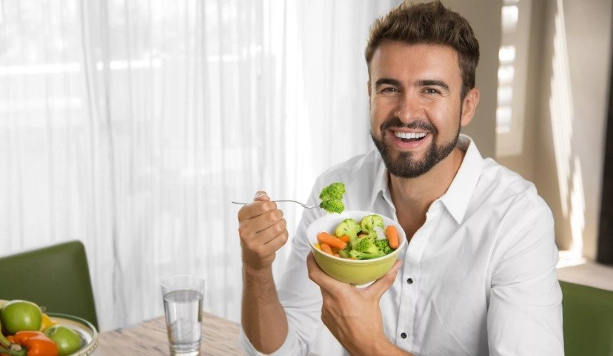 Мужчина ест овощной салат 