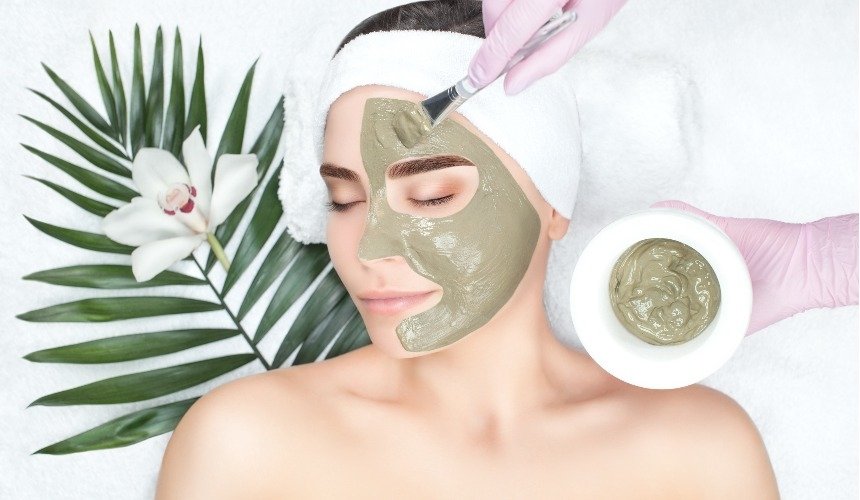 Женщине наносят маску для лица 