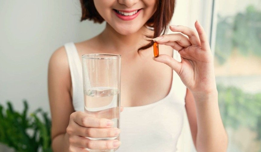 Девушка принимает витамины 