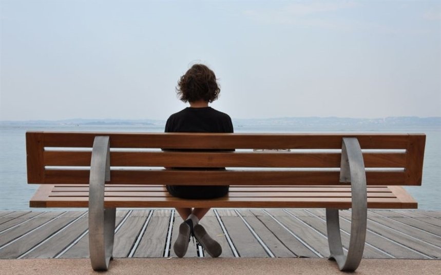 Одинокая девушка на скамейке